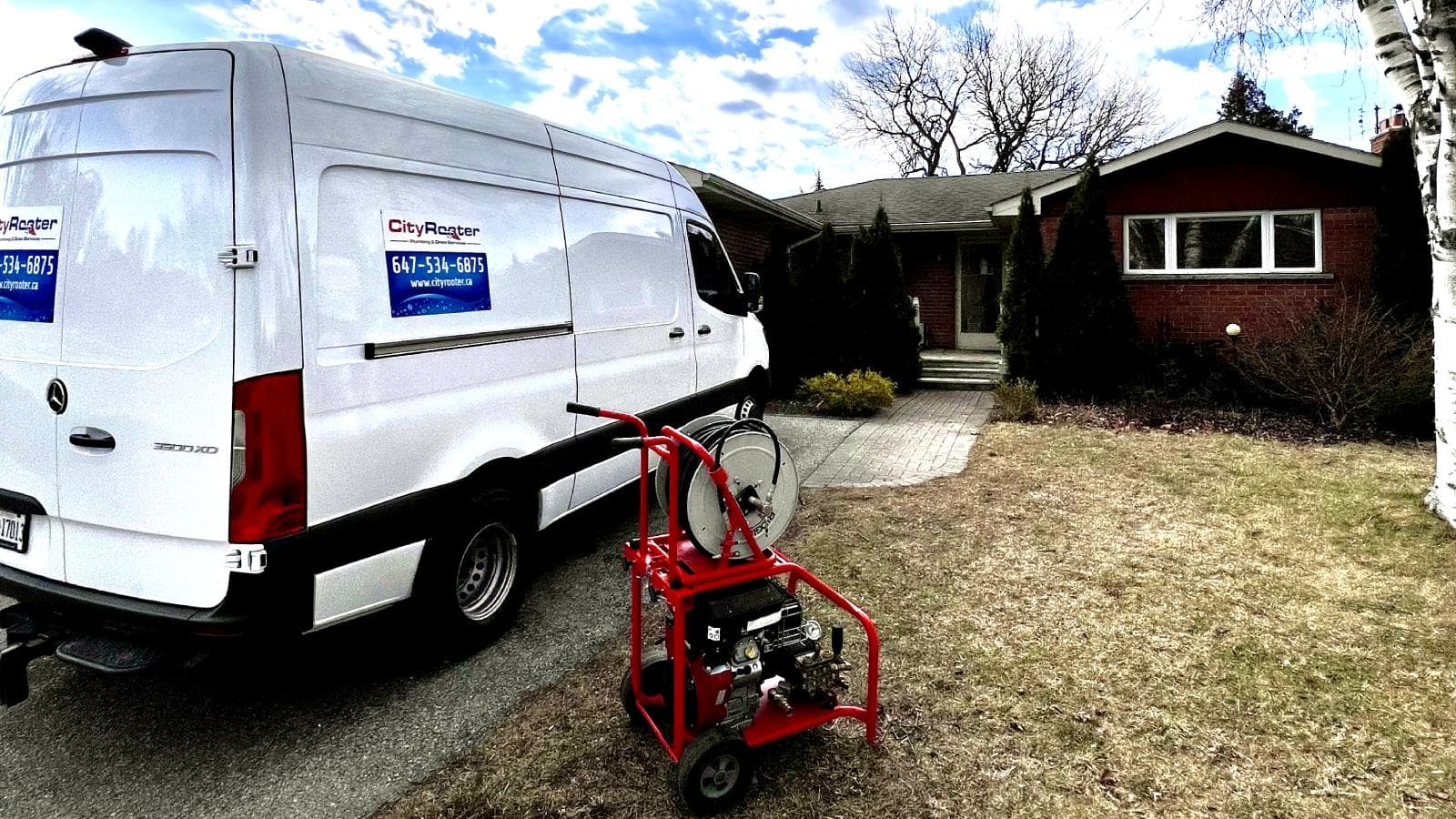 Plumber using a drain snake to clear a clogged kitchen drain